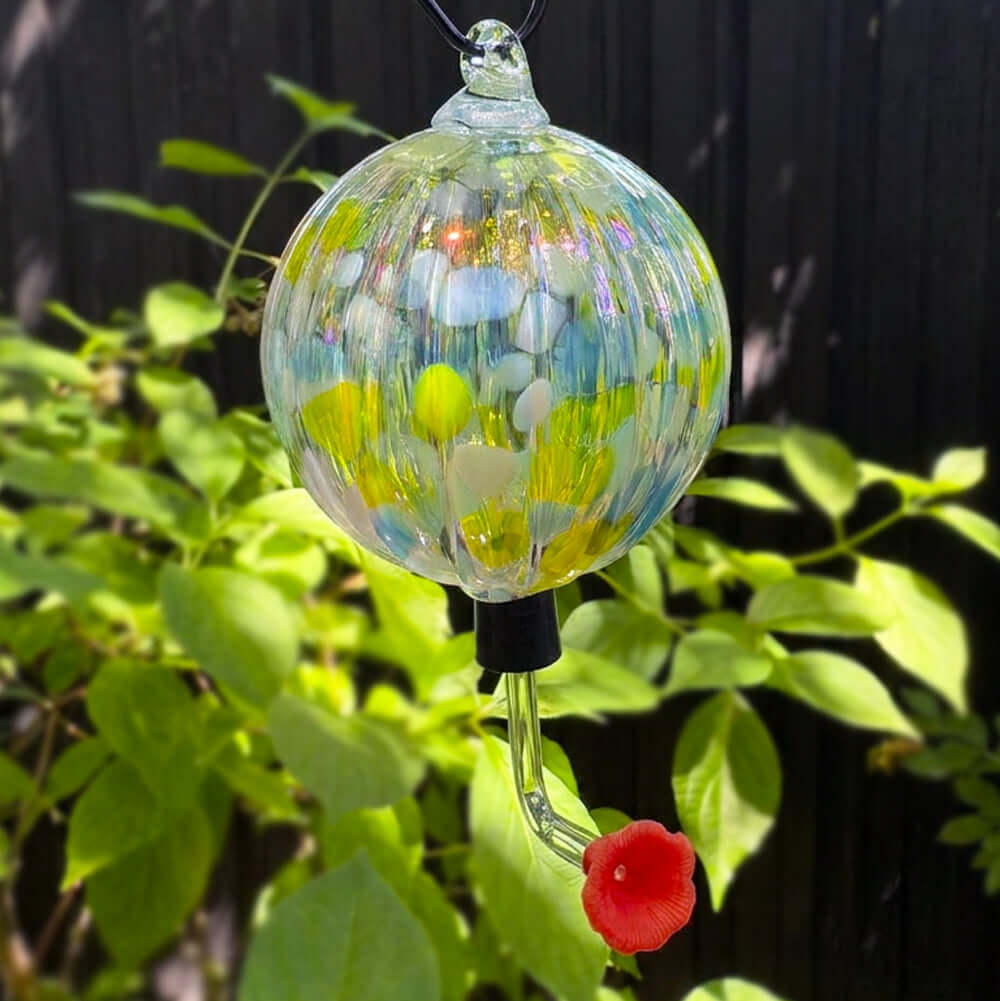 Colorful glass Buttercup garden ornament designed to attract hummingbirds, featuring a vibrant flower-shaped feeder.